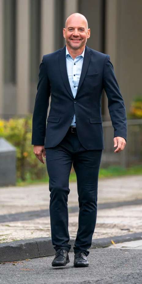 Male Escort Sascha walks towards camera with blue suit