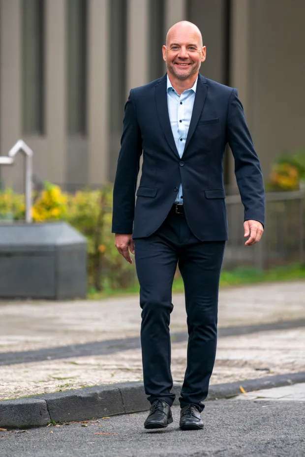Male Escort Sascha walks towards camera with blue suit